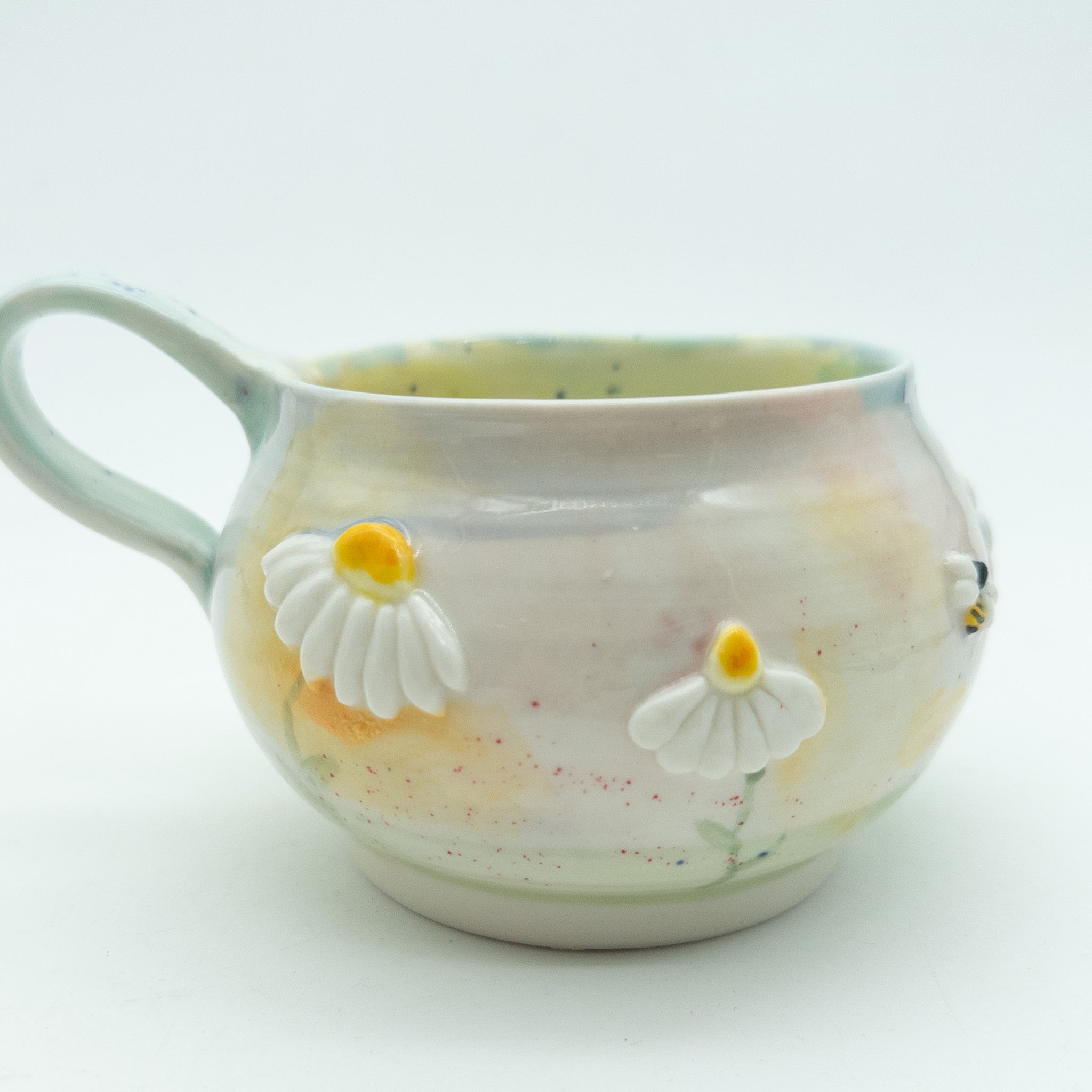 Kop med blomster og insekter