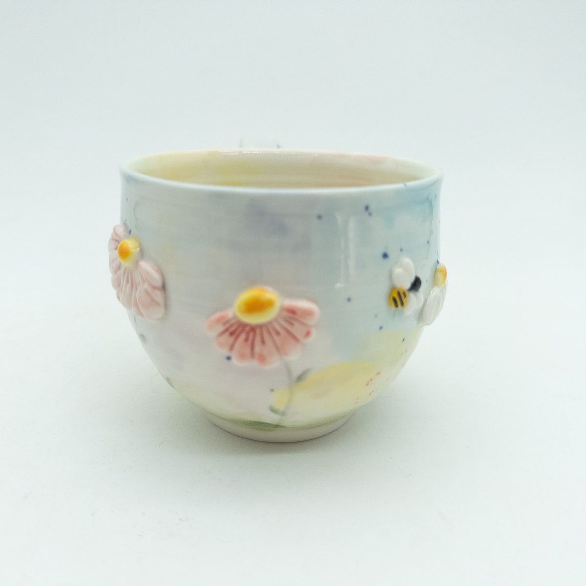 Kop med blomster og insekter