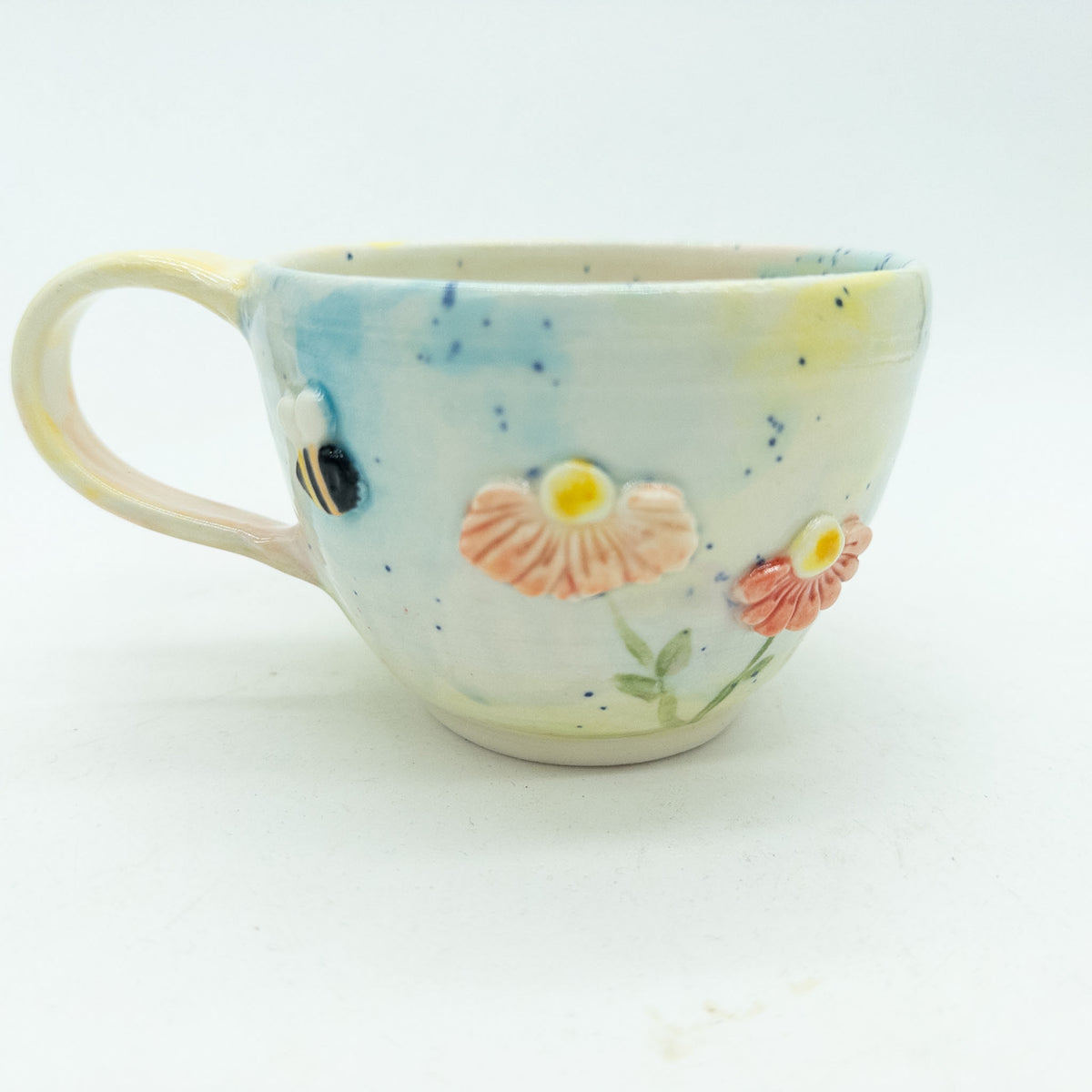 Kop med blomster og insekter